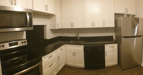White cabinets, black granite counter, vinyl wood flooring
